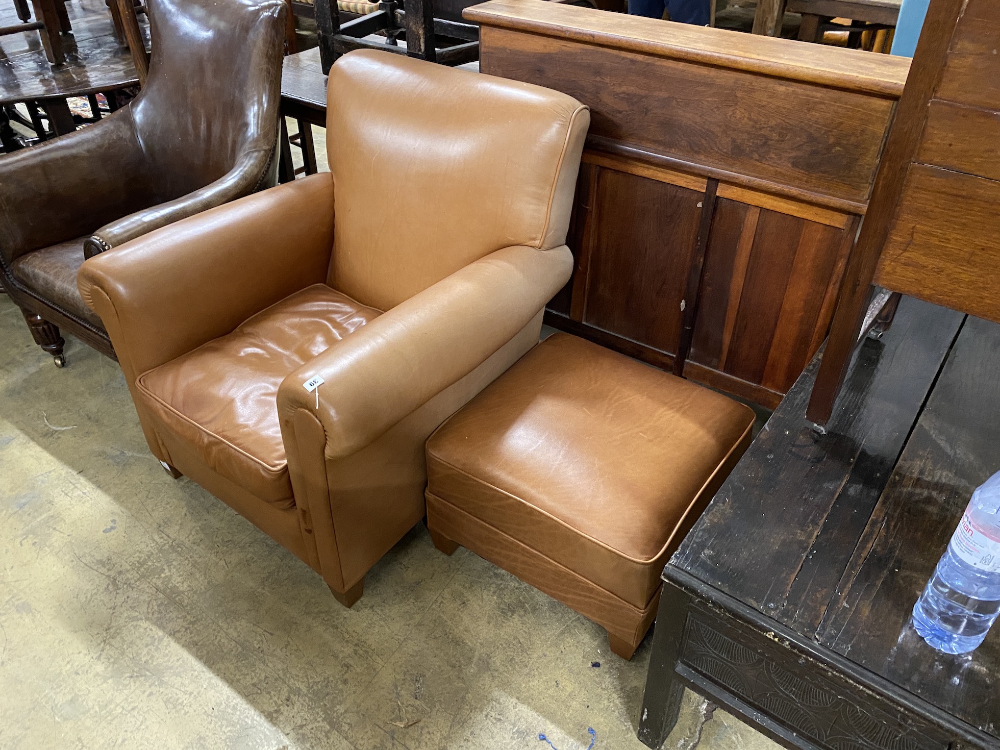 A contemporary brown leather upholstered armchair, width 84cm, depth 86cm, height 90cm and a footstool